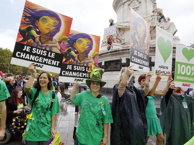 Climate protesters hold a banner reading “I am the change” on the Republique's square during a demonstration to fight climate change, on September 21, 2014 in Paris. (Photo by Francois Guillot/AFP Photo)