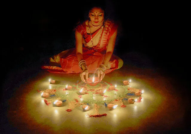 A girl lights earthen lamps on the eve of Diwali, the Hindu festival of lights in Kolkata, India on October 19, 2017. (Photo by Sanjay Purkait/Pacific Press)
