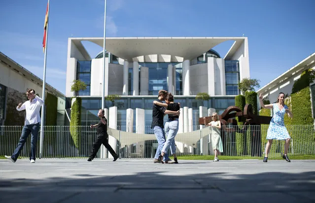 People dance in front of the Chancellery, office of German Chancellor Angela Merkel, in Berlin, Germany, Wednesday, June 3, 2020 on the occasion of the action day 'Save the world cultural heritage Tango Argentino in Germany'. With this action the dancers want to point out the problems of tango dancers and dance schools caused by the Corona pandemic. (Photo by Bernd von Jutrczenka/dpa via AP Photo)