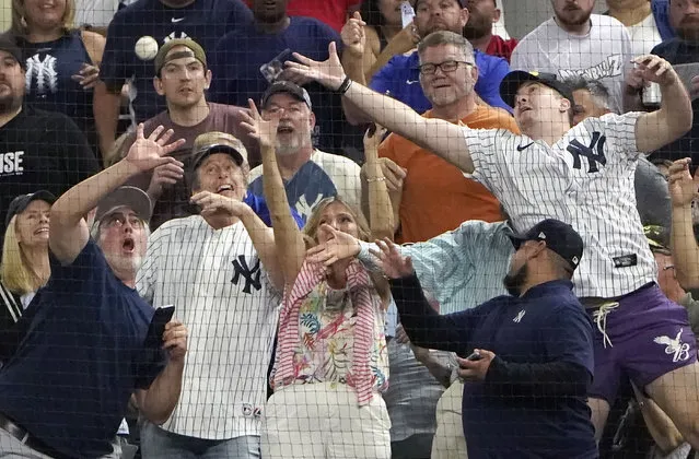 Fans reach for a foul ball by New York Yankees' Aaron Judge during the second inning in the second baseball game of a doubleheader against the Texas Rangers in Arlington, Texas, Tuesday, October 4, 2022. (Photo by L.M. Otero/AP Photo)