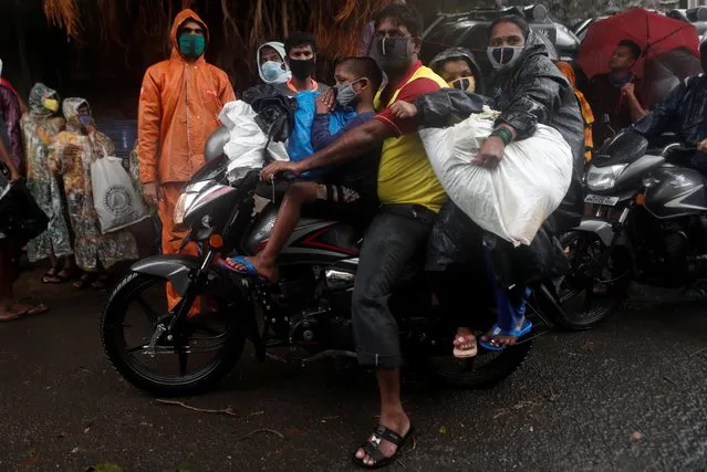A man rides a bike carrying his family and belongings during an evacuation of a slum off the coast of the Arabian sea as cyclone Nisarga makes its landfall, in Mumbai, India, June 3, 2020. (Photo by Francis Mascarenhas/Reuters)