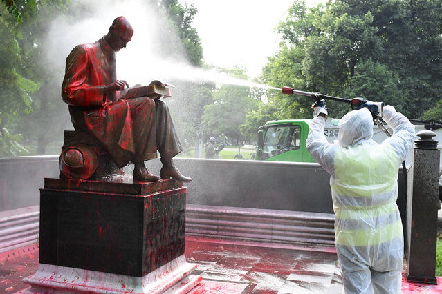 A municipal employee cleans a statue of a famous Italian journalist Indro Montanelli on June 14, 2020 in a Milan public square, a day after it was defaced, stained with red paint and tagged with the inscription “racist, rapist”. It is the first statue to be damaged in Italy since the wave of protests around the world triggered by the death of George Floyd in the US. (Photo by Miguel Medina/AFP Photo)