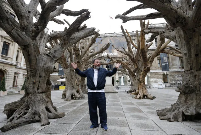 Chinese artist Ai Weiwei poses for photographers with one of his pieces at his exhibition at the Royal Academy of Arts in London, Tuesday, September 15, 2015. The exhibition opens to the public on September 19th. (Photo by Frank Augstein/AP Photo)
