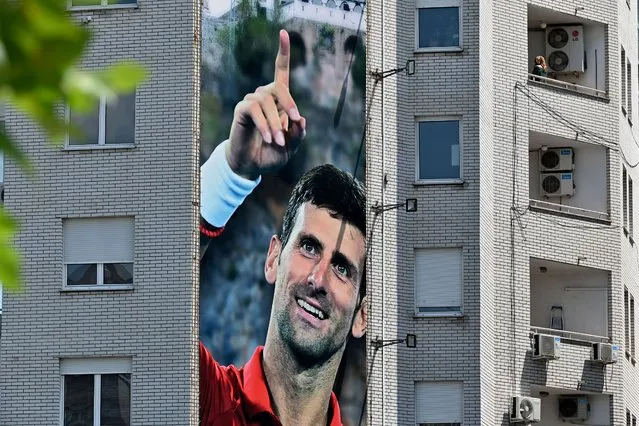 A billboard depicting Serbian tennis player Novak Djokovic and the Christian Orthodox monastery of Ostrog is seen on a building in Belgrade on June 24, 2020. Novak Djokovic has also tested positive for coronavirus on June 23, 2020 along with Grigor Dimitrov, Borna Coric and Viktor Troicki, after taking part in an exhibition tennis tournament in the Balkans featuring world number one Novak Djokovic, raising questions over the sport's planned return in August. (Photo by Andrej Isakovic/AFP Photo)