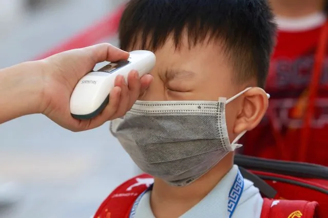 A primary school student undergoes a temperature check on the first day of class after the government eased a nationwide lockdown during the coronavirus disease (COVID-19) outbreak in Ho Chi Minh, Vietnam on May 11, 2020. (Photo by Yen Duong/Reuters)