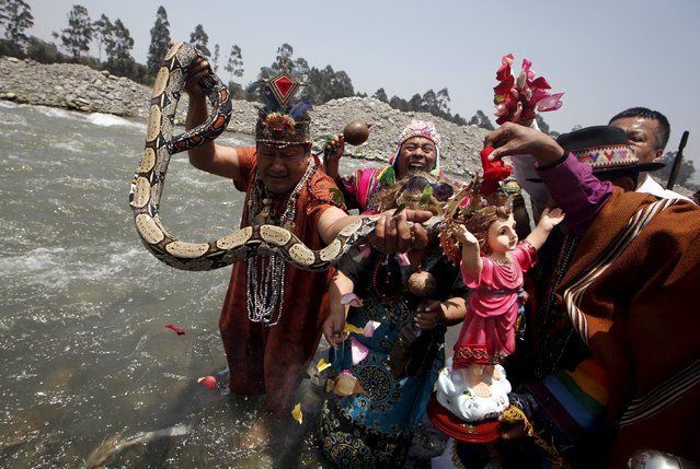 Peruvian shamans holding a figure of a Nino Jesus (Child Jesus) and a snake perform a ritual at the Rimac river to fight the negative effects of the Nino weather phenomena over Nature, in Lima, October 1, 2015. (Photo by Mariana Bazo/Reuters)