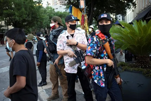 A Texas Guerrillas member who calls himself, “Apex”, third from right, and others carry weapons at a Black Lives Matter rally in Austin, Texas, August 1, 2020. Members of the armed groups said they were there to protect BLM protesters and their right to free speech. (Photo by Nuri Vallbona/Reuters)