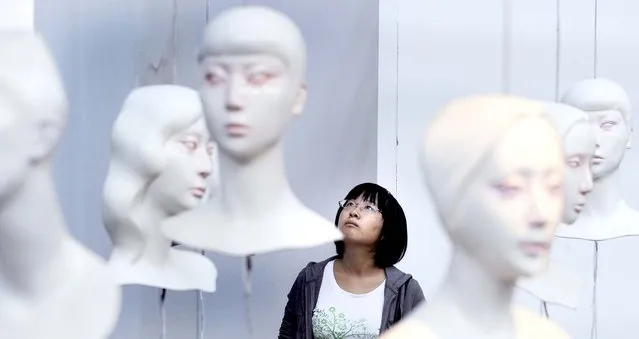 An attendee looks at art work at a gallery in Beijing. (Photo by Liu Jin/AFP Photo)