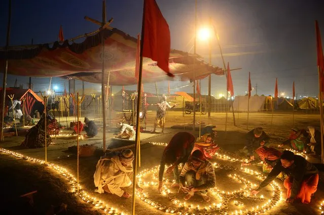 Indian devotees light oil lamps on the occasion of “Paush Purnima” at Sangam during the annual traditional fair Magh Mela at Sangam, the confluence of the rivers Ganges, Yamuna and the mythical Saraswati in Allahabad on January 2, 2018. (Photo by Sanjay Kanojia/AFP Photo)