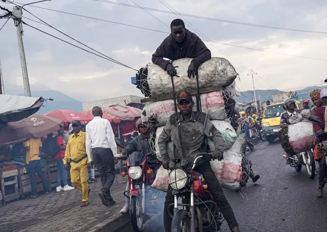 A motorcyclist transports sacks of charcoal down a street in Goma, eastern Democratic Republic of Congo, on December 2, 2022. M23 rebels have cut major supply routes to Goma, eastern DR Congo, sending prices in the city surging and sparking fears that a future offensive will cripple its economy A Tutsi-led group that lay dormant for years, the M23 took up arms again late last year, seizing swaths of territory in North Kivu province Last month, the rebels came within several dozen kilometres (miles) of Goma, a commercial hub of over one million people, on the border with Rwanda. (Photo by Glody Murhabazi/AFP Photo)