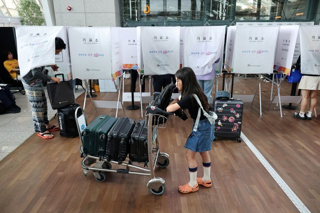 A girl waits for her mother as she votes during early voting for the upcoming presidential election at a polling station at the Incheon International airport in Incheon, South Korea, on May 29, 2025. (Photo by Kim Hong-Ji/Reuters)