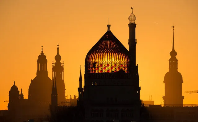 The Dresden Frauenkirche (L- R), the Dresden Cathedral, the former factory building of the cigarette factory Yenidze and the Castle tower stand out against the sunrise in Dresden, Germany, 13 December 2017. (Photo by Sebastian Kahnert/DPA/Zentralbild)