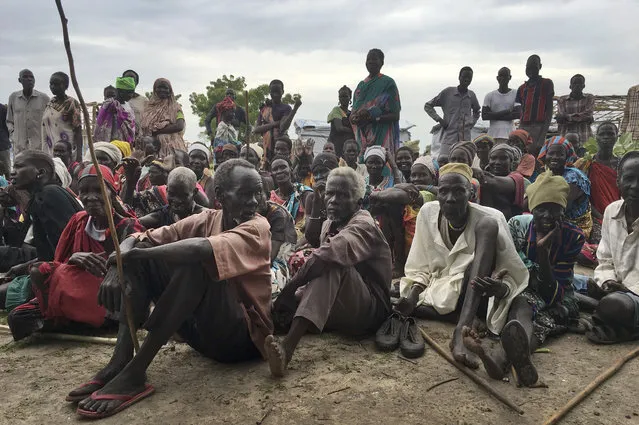 In this Sunday, June 18, 2017 file photo, displaced South Sudanese gather during a visit of UNCHR High Commissioner Filippo Grandi to a new site for displaced people outside of the U.N. protected camp, in Bentiu, South Sudan. Nearly four years after the United Nations threw open its doors to civilians fleeing South Sudan's civil war, more than 200,000 people still shelter in the often squalid camps but now the government is trying to entice them to go home, even as fighting rages on. (Photo by Sam Mednick/AP Photo)