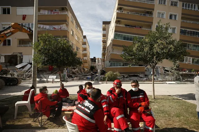 Member of rescue services take a break during search operations in the debris of a collapsed building for survivors in Izmir, Turkey, Sunday, November 1, 2020. Rescue teams continue ploughing through concrete blocs and debris of collapsed buildings in Turkey's third largest city in search of survivors of a powerful earthquake that struck Turkey's Aegean coast and north of the Greek island of Samos, Friday Oct. 30, killing dozens Hundreds of others were injured. (Photo by Emrah Gurel/AP Photo)