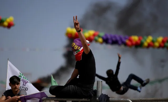 People gesture during a gathering celebrating Newroz, which marks the arrival of spring and the new year, in Diyarbakir, Turkey March 21, 2018. (Photo by Sertac Kayar/Reuters)