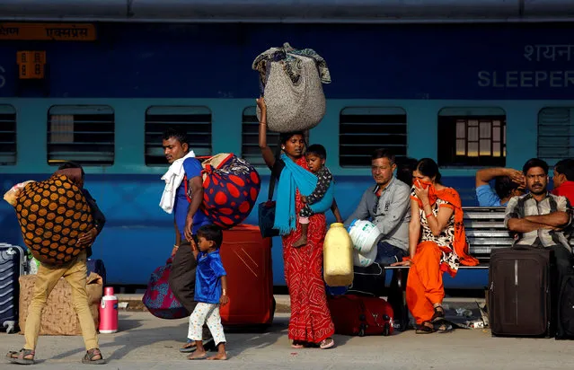 Passengers walk along a platform carrying luggage at a railway station in New Delhi, India, April 3, 2018. (Photo by Saumya Khandelwal/Reuters)