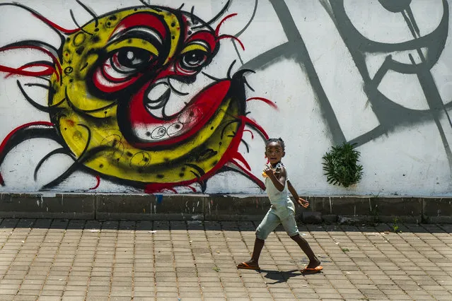 A child walks past a COVID-19 graffiti in Soweto's Orlando West township near Johannesburg, South Africa, Thursday November 19, 2020. Africa has surpassed 2 million confirmed coronavirus cases as the continent's top public health official warns that “we are inevitably edging toward a second wave” of infections. The 54-nation continent of 1.3 billion people is being warned against “prevention fatigue” as countries loosen pandemic restrictions to ease their economies’ suffering and more people travel. (Photo by Jerome Delay/AP Photo)