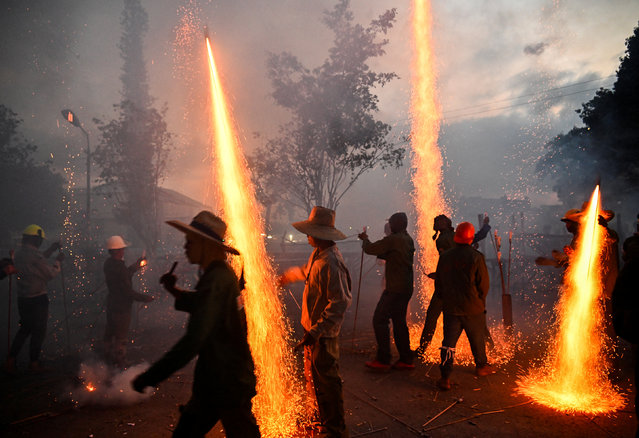 People paly with fireworks during Parrandas de Camajuani, Cuba on March 22, 2025. Two neighborhoods of the city, San Jose, represented by a toad, and Santa Teresa, represented by a goat, fight with carnival shows that involve the whole town in a party with bands, huge floats and fireworks. The Parrandas de Camajuani with more than 130 years, are recognized as Intangible Cultural Heritage of Humanity since 2018. (Photo by Yamil Lage/AFP Photo)