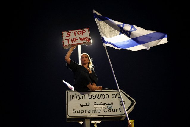 A protester holds a sign during a demonstration against Israeli Prime Minister Benjamin Netanyahu's government, near the Knesset, the Israeli parliament, in Jerusalem on June 17, 2024. (Photo by Eloisa Lopez/Reuters)