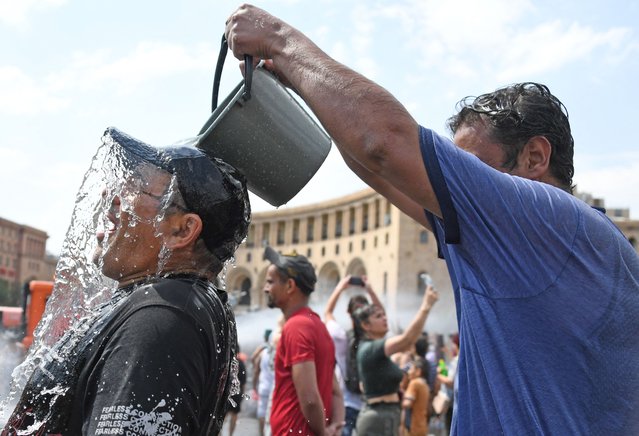 Particpants splash each other with water in Yerevan on July 7, 2024, as they take part in the annual Vardavar Festival. Vardavar is a traditional Armenian water festival, with people drenching each other with water, dating back to pagan times. The ancient festival is traditionally associated with the goddess Astghik, who was the goddess of water, beauty, love, and fertility. (Photo by Karen Minasyan/AFP Photo)