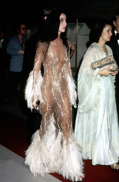 American singer Cher looks ethereal in a see-through, sequinned, and feathered confection at the Met Gala, on November 20, 1974 in Hollywood. (Photo by Ron Galella/Ron Galella Collection/Getty Images)