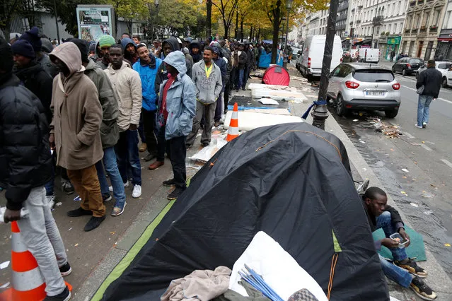Migrants queue for a free meal distributed by the Adventist Development and Relief Agency International (ADRA) humanitarian agency on a street near Stalingrad metro station in Paris, France, October 28, 2016. (Photo by Charles Platiau/Reuters)
