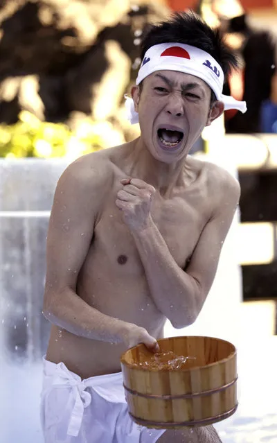A half-naked shrine parishioner reacts after pouring cold water onto himself during an annual cold-endurance festival at the Kanda Myojin Shinto shrine in Tokyo, Saturday, January 10, 2015. (Photo by Eugene Hoshiko/AP Photo)