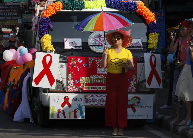 A Thai transgender woman stands in front placards as activists march through Pattaya resort town to raise awareness on the World Aids Day in Pattaya, east of Bangkok, Thailand December 1, 2015. (Photo by Chaiwat Subprasom/Reuters)