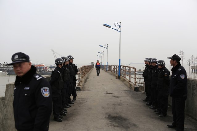 Police stand guard at a pier after a tug boat sank in the Yangtze River near Jingjiang, Jiangsu province, January 16, 2015. (Photo by Aly Song/Reuters)