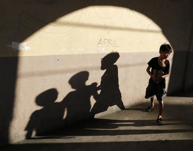 Filipino street children walk at a side street in Muntinlupa city, south of Manila, the Philippines, December 3, 2015. The Department of Social Welfare and Development (DSWD) has asked local government units in Metro Manila for help in discouraging children from doing caroling activities on the streets as Christmas season is fast approaching. The streets pose a hazard to children's safety even if they are doing a harmless activity such as caroling.  (Photo by Francis R. Malasig/EPA)