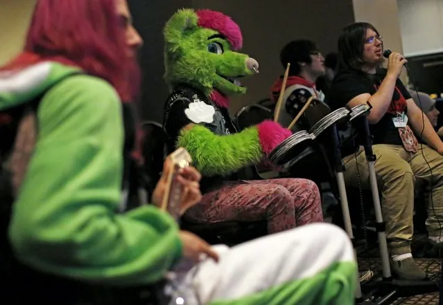 An attendee in a "fursuit" costume (2nd L) plays the drums as he joins others playing a video game at the Midwest FurFest in the Chicago suburb of Rosemont, Illinois, United States, December 4, 2015. (Photo by Jim Young/Reuters)