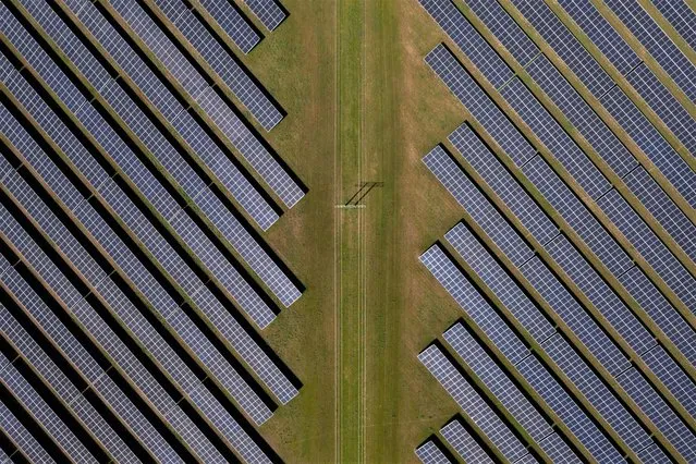 An aerial view shows photovoltaic panels at a solar farm near Thaxted, eastern England, on May 16, 2023. (Photo by Daniel Leal/AFP Photo)