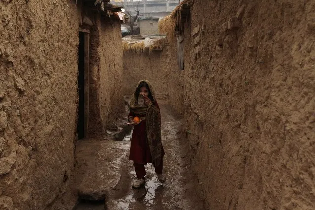 A girl walks on a muddy alley on her way home in a slum area on the outskirts of Islamabad January 21, 2015. (Photo by Faisal Mahmood/Reuters)