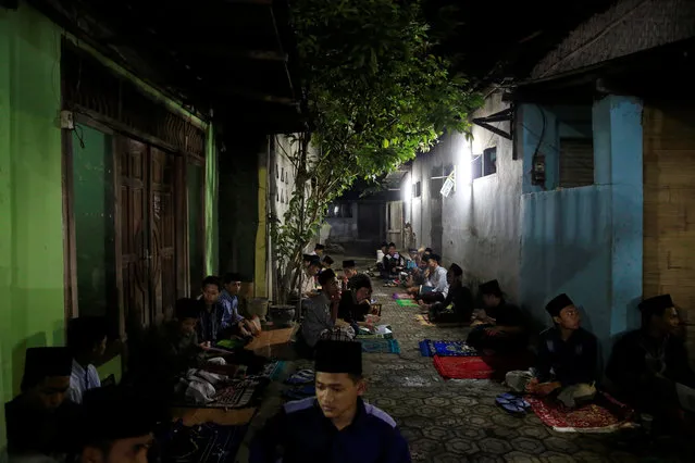 Students sit outside as they learn Islamic scriptures in the evening during the holy month of Ramadan at Lirboyo Islamic boarding school in Kediri, Indonesia, May 24, 2018. (Photo by Reuters/Beawiharta)