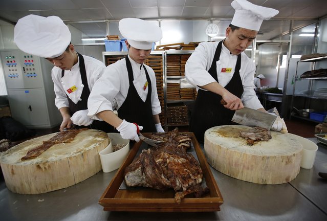 Cooks cut grilled lamb meats at a Mongolian style restaurant Nine-Nine Yurts in Beijing February 10, 2015. (Photo by Kim Kyung-Hoon/Reuters)