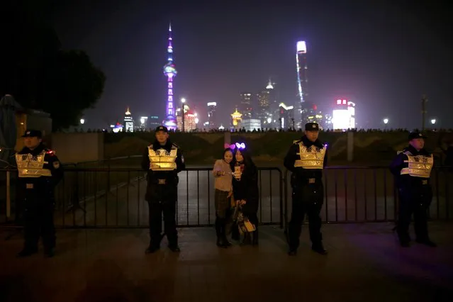 Women pose for a selfie next to police officers at the location where a stampede incident occurred during New Year celebrations a year ago, on the Bund in Shanghai, China, December 31, 2015. Authorities in the Chinese city of Shanghai have opted not to organize New Year celebrations the historic riverfront Bund this week, a year after a stampede killed 36 people. (Photo by Aly Song/Reuters)