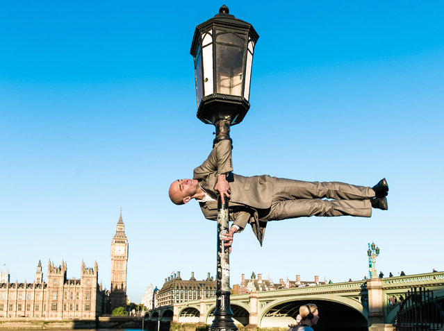 From London to New York! These action shots show talented athletes practising yoga poses in iconic city locations. The amazing snaps were taken by photographer Kristina Kashtanova at urban street locations in the UK and New York. The talented yogis are seen striking mind-boggling poses in the most unusual settings. Here: Suited London in front of Big Ben, London. (Photo by Kristina Kashtanova/Caters News)
