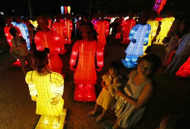 Members of the public stand and walk next to an art installation called the “Lanterns of the Terracotta Warriors” in front of the Sydney Harbour Bridge February 19, 2015. (Photo by David Gray/Reuters)