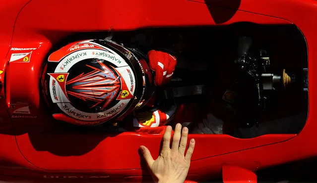Kimi Raikkonen of Finland and Ferrari is pulled by technicians to the garage during the 2015 Formula One testing at the Barcelona Catalunya racetrack in Montmelo, Spain, Thursday, February 19, 2015. (Photo by Manu Fernandez/AP Photo)