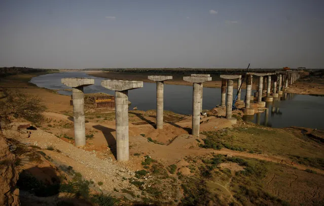 In this photo taken Wednesday, April 30, 2014, a bridge is seen under construction on the Chambal River near Sagarpada in the western Indian state of Rajasthan. (Photo by Altaf Qadri/AP Photo)