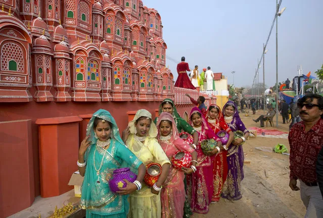Folk artists from the western Indian state of Rajasthan pose for a photograph in front of a tableau depicting Jaipur’s famous Hawa Mahal, during a media preview of tableaus participating in the Republic Day parade, in New Delhi, India, Friday, January 22, 2016. (Photo by Manish Swarup/AP Photo)