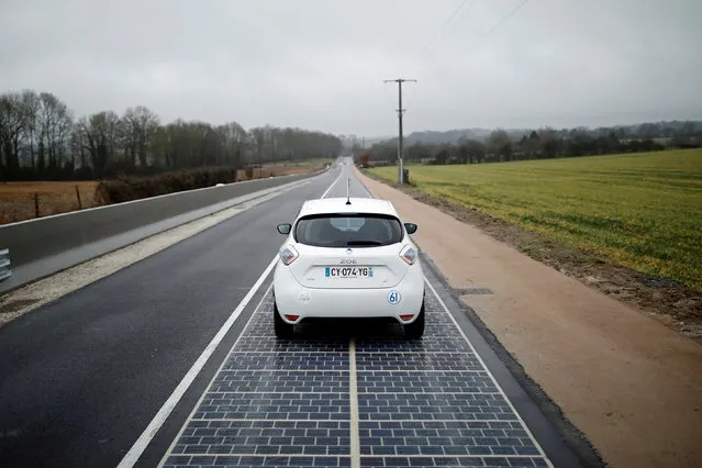 An automobile drives on a solar panel road during its inauguration in Tourouvre, Normandy, northwestern France, December 22, 2016. (Photo by Benoit Tessier/Reuters)