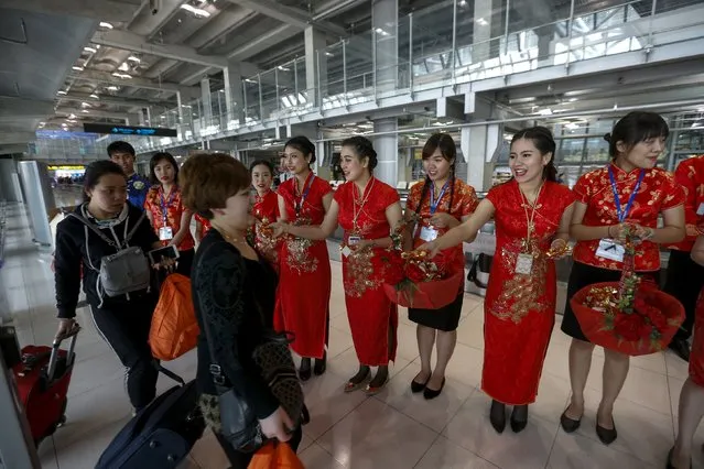 Chinese tourists receive souvenirs from airport officers as part of the Chinese Lunar New Year celebrations at Bangkok's Suvarnabhumi Airport, Thailand, February 5, 2016. (Photo by Athit Perawongmetha/Reuters)
