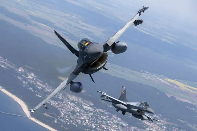 A Romanian Air Force F- 16s military fighter jet, left, and a Portuguese Air Force F- 16s military fighter jets participating in NATO's Baltic Air Policing Mission operate over the Baltic Sea, Lithuanian airspace, on May 22, 2023. The United States has given its approval for the Netherlands to deliver F-16s to Ukraine, the Dutch defense minister said Friday, Aug. 18, 2023 in a major gain for Kyiv even though the fighter jets won’t have an immediate impact on the almost 18-month war. (Photo by Mindaugas Kulbis/AP Photo)