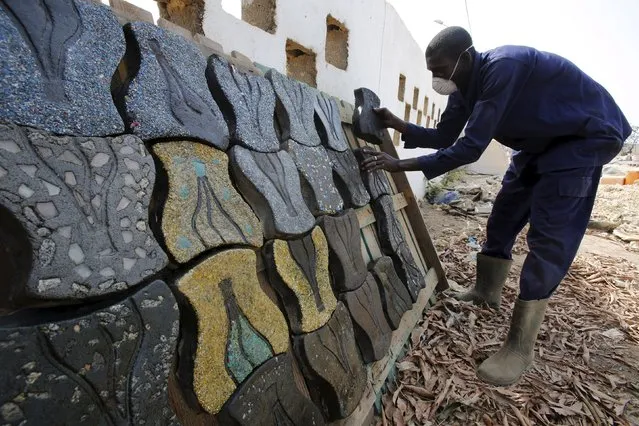 A former rebel of Ivory Coast's civil war works on paver tiles made with recycled plastic as part of the Ivorian government's Demobilization, Disarmament, and Reintegration (DDR) plan for ex-fighters in Bouake, Ivory Coast, February 10, 2016. (Photo by Thierry Gouegnon/Reuters)