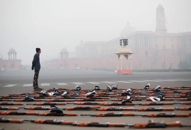 An Indian Air Force soldier stands guard next to rifles during a break at the rehearsal for the Republic Day parade on a cold winter morning in New Delhi, India, December 26, 2018. (Photo by Adnan Abidi/Reuters)
