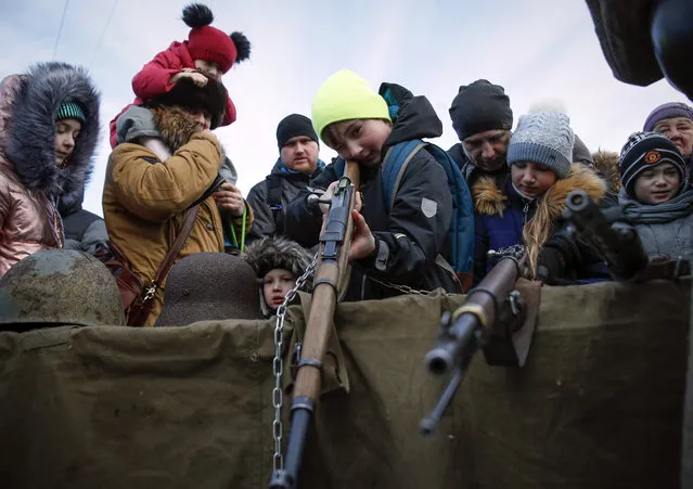 Children aim with World War II Soviet guns during a military exhibition marking the 75th anniversary of the end of the Siege of Leningrad during World War II, at the Dvortsovaya (Palace) Square in in St.Petersburg, Russia, Sunday, January 13, 2019. The Nazi German and Finnish siege and blockade of Leningrad, now known as St. Petersburg, was broken on Jan. 18, 1943 but finally lifted Jan. 27, 1944. More than 1 million people died mainly from starvation during the 900-day siege. (Photo by Dmitri Lovetsky/AP Photo)