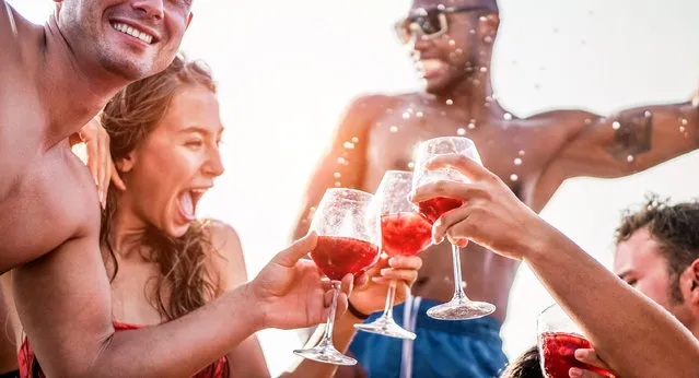 Happy friends drinking sangria wine at exclusive boat party. Young people having fun in summer vacation. Travel, friendship, holidays and youth lifestyle concept. (Photo by DisobeyArt/Getty Images)