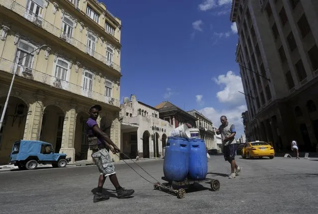 A man pushes tanks with water for his house in Havana February 19, 2016. (Photo by Enrique de la Osa/Reuters)