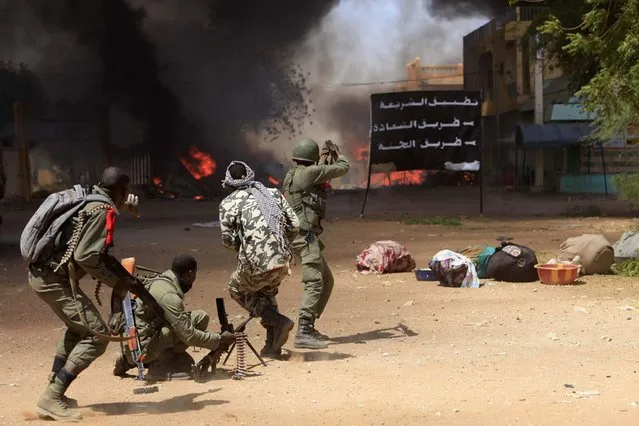 Malian soldiers fight while clashes erupted in the city of Gao on February 21, 2013 and an apparent car bomb struck near a camp housing French troops as Malian and foreign forces struggled to secure Mali's volatile north against Islamist rebels. (Photo by Frederic Lafargue/AFP Photo)
